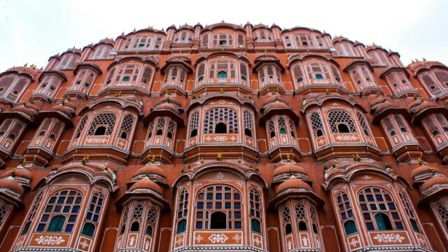 Low angle view of the iconic Hawa Mahal showcasing its elaborate facade in Jaipur, India.